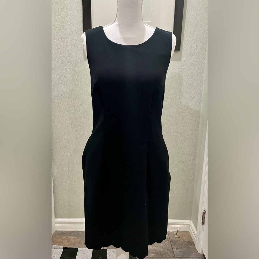 Black sleeveless black dress with pockets and scalloped bottom hem. Size M